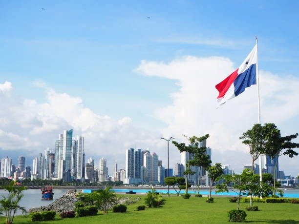 Panama City / Panama - September 1 2019: City skyline with green grass and flag flying. Blue sky and white clouds.